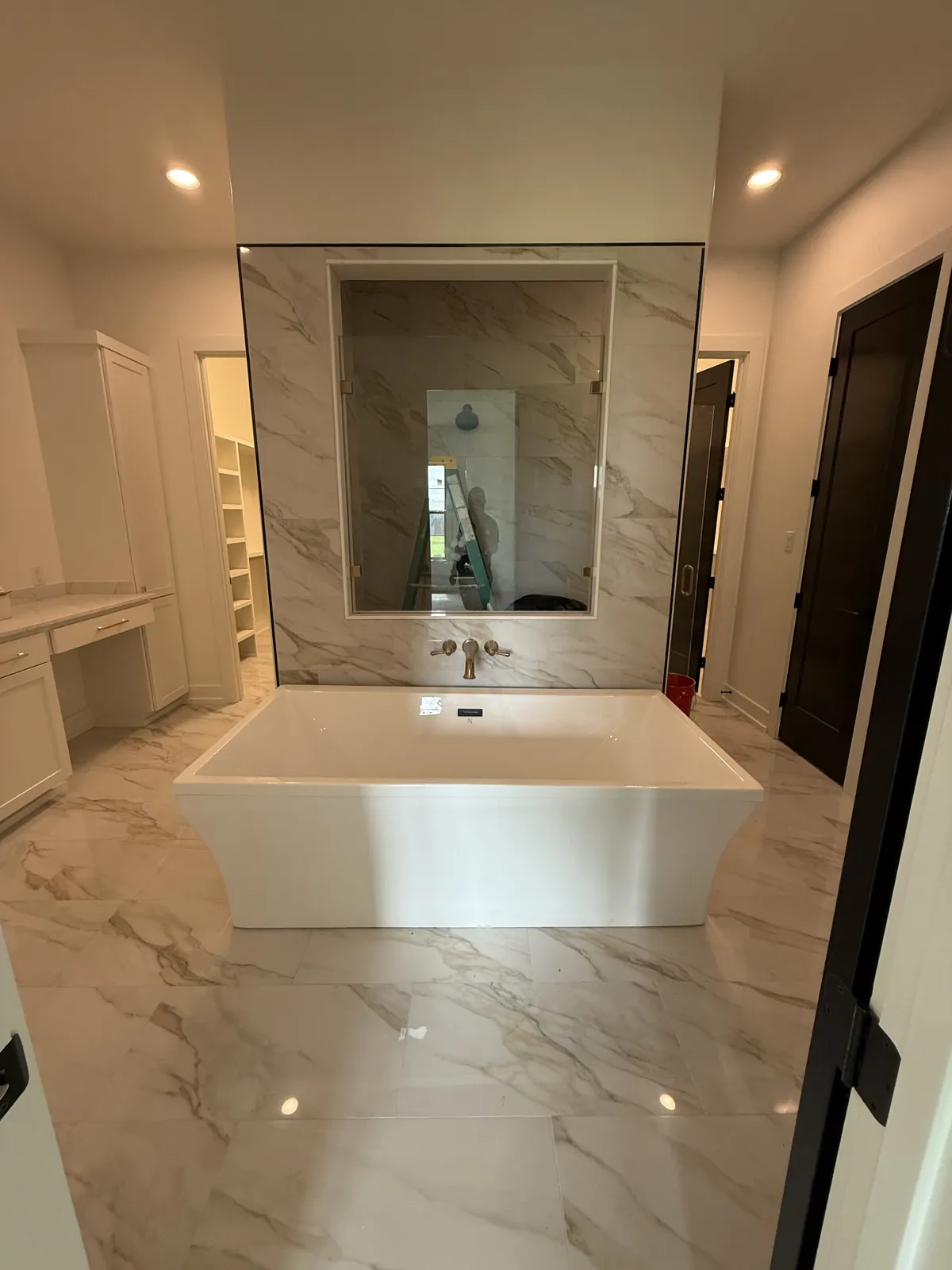 Bathroom with freestanding tub and large marble-look floor tile