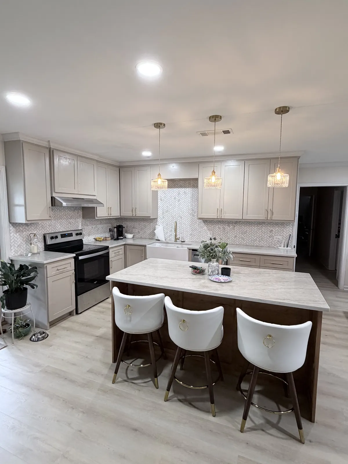 Kitchen with light cabinets, wood-front island and pendant lights