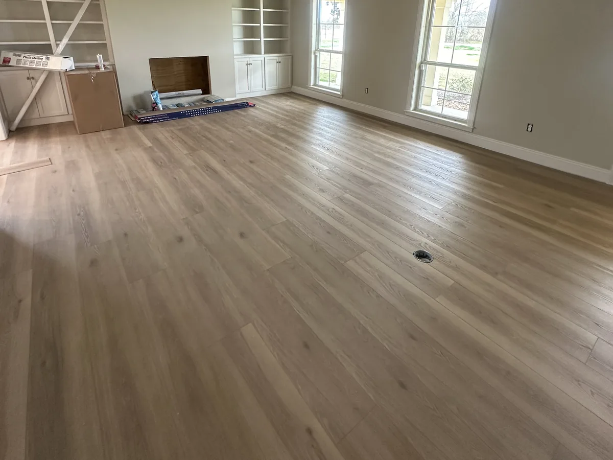 New light wood-look plank flooring across a large vaulted living room