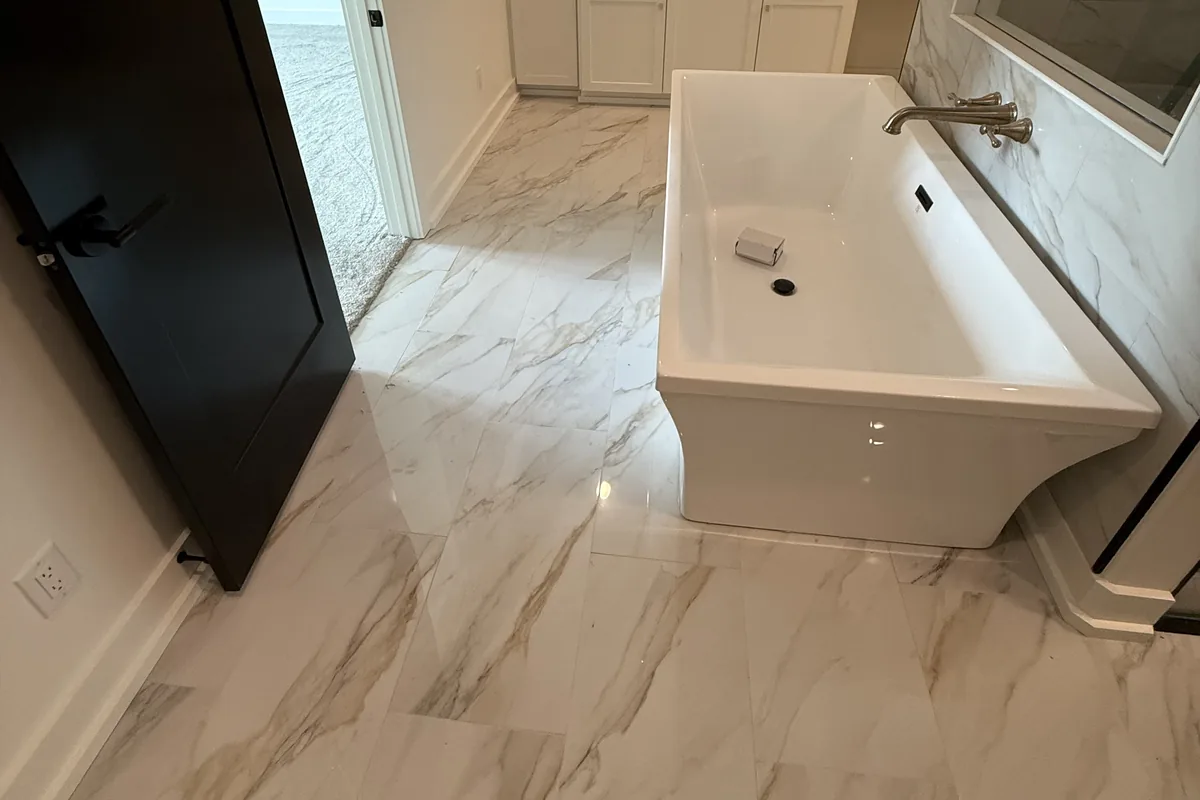 Remodeled bathroom with a freestanding tub and marble-look porcelain floor
